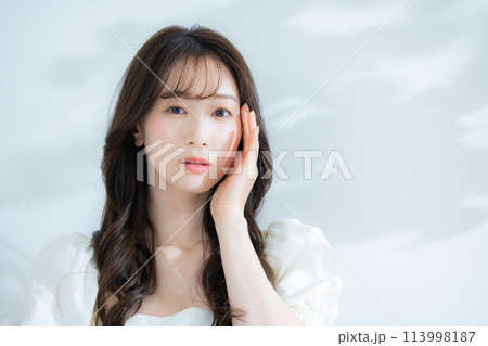 麦わら帽子を持つ女性 113998187