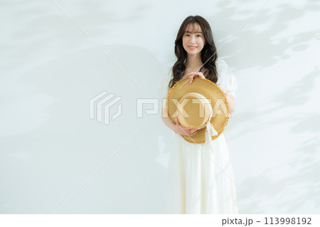 麦わら帽子を持つ女性 113998192