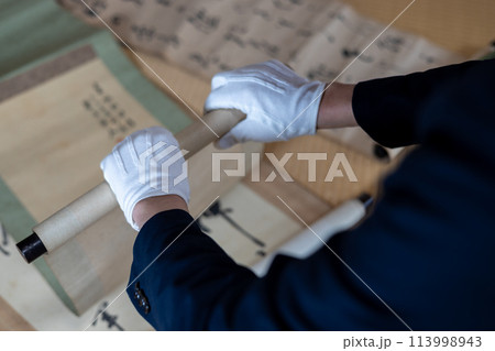 古い掛け軸を鑑定している男性 古い掛け軸を鑑定している男性 113998943