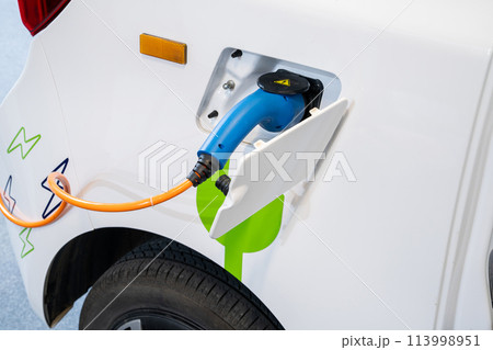 Close up of electric car inlet with a connected charging cable Close up of electric car inlet with a connected charging cable 113998951