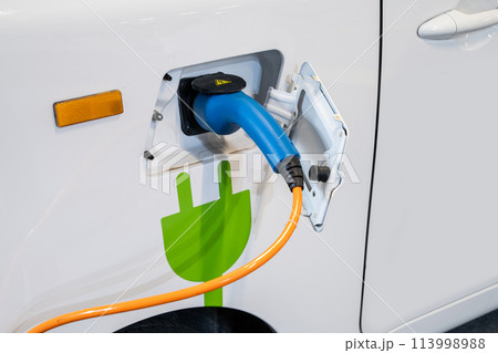 Close up of electric car inlet with a connected charging cable Close up of electric car inlet with a connected charging cable 113998988