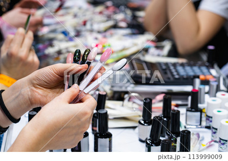 Woman chooses nail polish in a cosmetics store Woman chooses nail polish in a cosmetics store 113999009