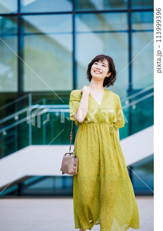 屋外を歩くワンピース姿の若い女性 113999396