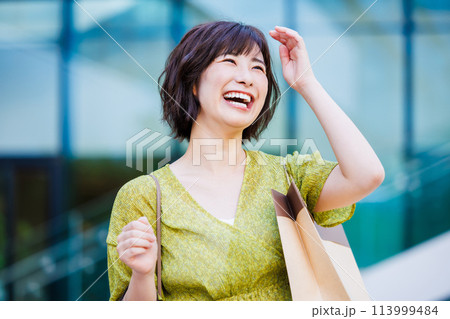 屋外を歩くワンピース姿の若い女性 113999484