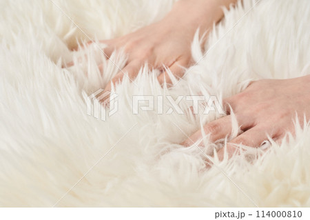 ふわふわした生地を触る女性の手元 114000810
