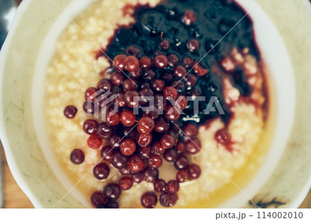 Warm wheat porridge with red currants and blueberry jam.A close-up of a plate of wheat porridge for a healthy gluten-free breakfast. High quality photo Warm wheat porridge with red currants and blueberry jam.A close-up of a plate of wheat porridge for a healthy gluten-free breakfast. High quality photo 114002010