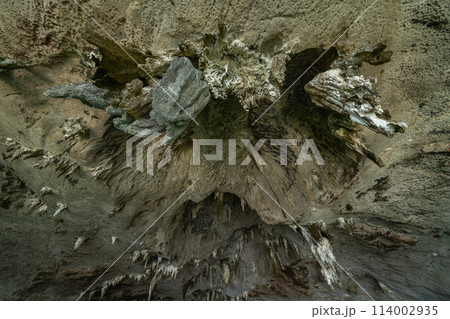 Natural stalactite and stalagmite rock stone cliff hang from cave ceiling in cave with lake river sea. Environmental explore. Landscape background. Erosion Natural stalactite and stalagmite rock stone cliff hang from cave ceiling in cave with lake river sea. Environmental explore. Landscape background. Erosion 114002935