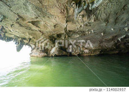 Natural stalactite and stalagmite rock stone cliff hang from cave ceiling in cave with lake river sea. Environmental explore. Landscape background. Erosion 114002937