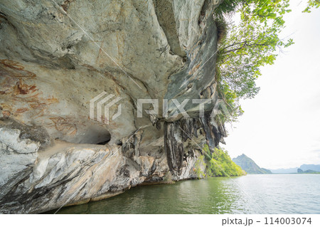Natural stalactite and stalagmite rock stone cliff hang from cave ceiling in cave with lake river sea. Environmental explore. Landscape background. Erosion 114003074