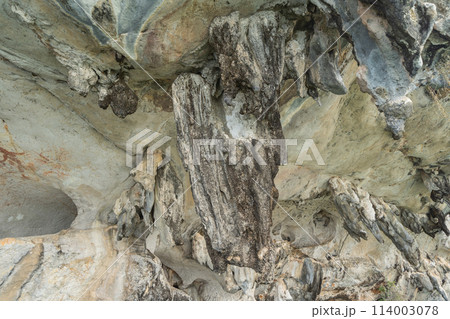 Natural stalactite and stalagmite rock stone cliff hang from cave ceiling in cave with lake river sea. Environmental explore. Landscape background. Erosion 114003078