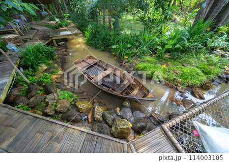 Sailing local wooden boat in the sea ocean and tree forest. Nature environment landscape background. Sailing local wooden boat in the sea ocean and tree forest. Nature environment landscape background. 114003105