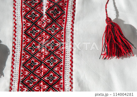 Ukrainian clothes embroidered shirt. Red orange and black threads background. Vyshyvanka is a symbol of Ukraine. Embroidery cross stitching. National Ukrainian stitch. Traditional clothing symbol Ukrainian clothes embroidered shirt. Red orange and black threads background. Vyshyvanka is a symbol of Ukraine. Embroidery cross stitching. National Ukrainian stitch. Traditional clothing symbol 114004281