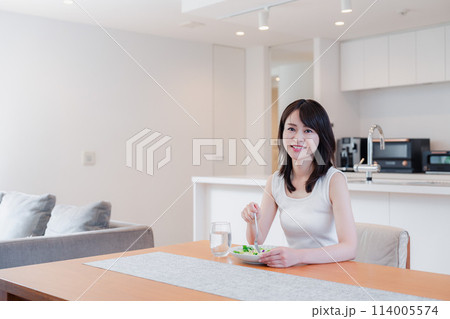 家でご飯を食べる若い女性 114005574