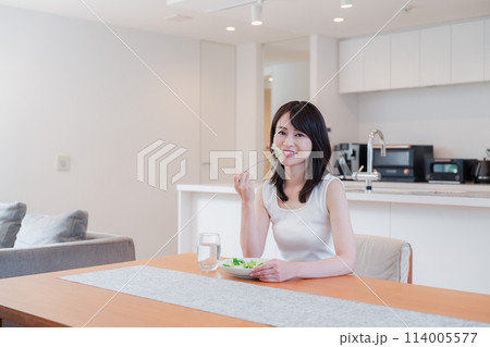 家でご飯を食べる若い女性 114005577
