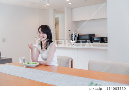 家でご飯を食べる若い女性 114005580
