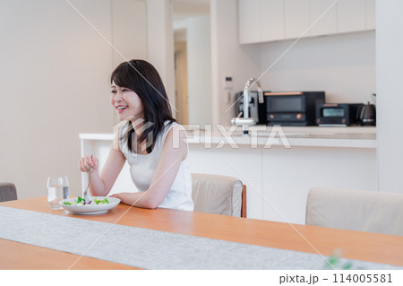 家でご飯を食べる若い女性 114005581