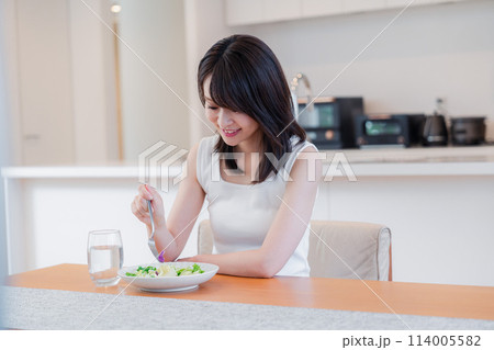 家でご飯を食べる若い女性 114005582