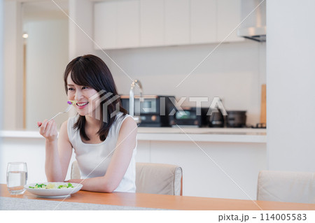 家でご飯を食べる若い女性 114005583