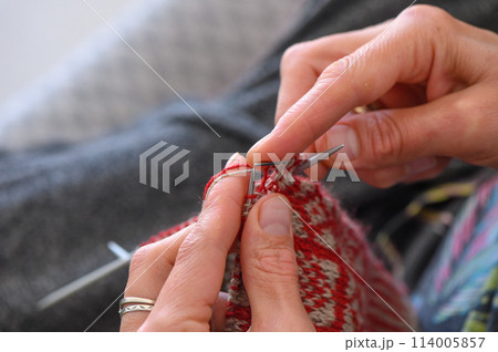 woman sitting on sofa, skillfully knitting warm socks 1 woman sitting on sofa, skillfully knitting warm socks 1 114005857