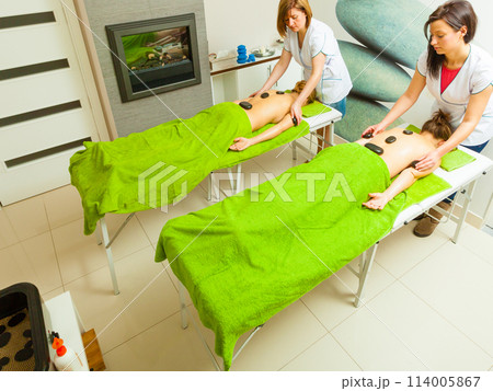 Massage with hot rocks stones in beautician 114005867