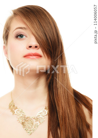 Portrait of girl with bang covering eye in golden necklace 114006057