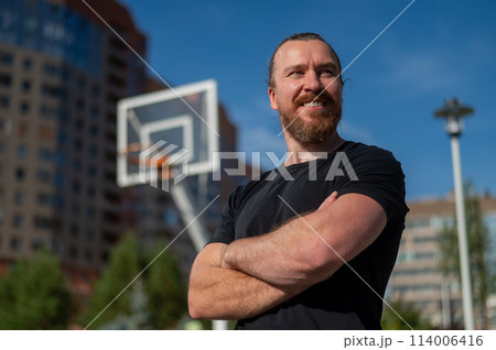 Portrait of a Caucasian bearded man on a basketball court outdoors.  114006416