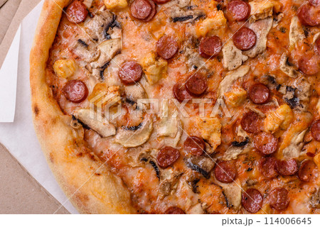 Delicious pizza with sausage, cheese, tomatoes, salt, spices and herbs 114006645