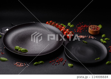 Ingredients salt, spices, herbs and tomatoes on a dark concrete background Ingredients salt, spices, herbs and tomatoes on a dark concrete background 114006684
