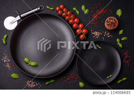 Ingredients salt, spices, herbs and tomatoes on a dark concrete background Ingredients salt, spices, herbs and tomatoes on a dark concrete background 114006685