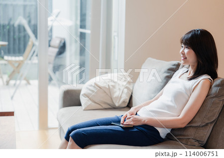 家でテレビを見る若い女性 114006751