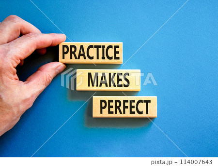 Practice makes perfect symbol. Concept words Practice makes perfect on wooden block. Beautiful blue table blue background. Businessman hand. Business practice makes perfect concept. Copy space. 114007643