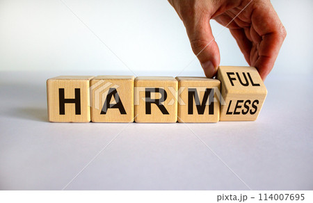 Male hand turns the cube and changes the expression 'harmless' to 'harmful' or vice versa. Beautiful white background. Concept. Copy space. Male hand turns the cube and changes the expression 'harmless' to 'harmful' or vice versa. Beautiful white background. Concept. Copy space. 114007695