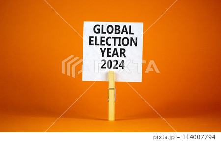Global election year 2024 symbol. Concept words Global election year 2024 on beautiful white paper on clothespin. Beautiful orange background. Business Global election year 2024 concept. Copy space Global election year 2024 symbol. Concept words Global election year 2024 on beautiful white paper on clothespin. Beautiful orange background. Business Global election year 2024 concept. Copy space 114007794