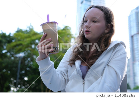 Cheerful kid showing like gesture and holding milkshake banner. bubble tee High quality photo 114008268