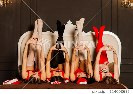 Four pretty women with curly hair and red Christmas lingerie. New year background. 114008655