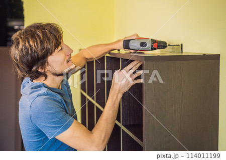 Frustrated Man Putting Together Self Assembly Furniture Frustrated Man Putting Together Self Assembly Furniture 114011199