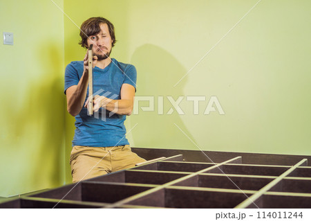 Frustrated Man Putting Together Self Assembly Furniture Frustrated Man Putting Together Self Assembly Furniture 114011244