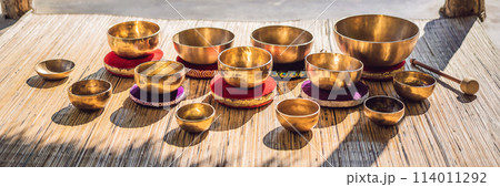 Tibetan singing bowls on a straw mat against a waterfall BANNER, LONG FORMAT Tibetan singing bowls on a straw mat against a waterfall BANNER, LONG FORMAT 114011292