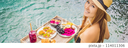 BANNER, LONG FORMAT Breakfast tray in swimming pool, floating breakfast in luxury hotel. Girl relaxing in the pool drinking smoothies and eating fruit plate, smoothie bowl by the hotel pool. Exotic BANNER, LONG FORMAT Breakfast tray in swimming pool, floating breakfast in luxury hotel. Girl relaxing in the pool drinking smoothies and eating fruit plate, smoothie bowl by the hotel pool. Exotic 114011306
