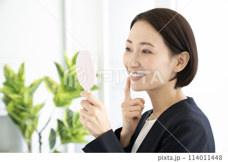 鏡を見て微笑む女性 鏡を見て微笑む女性 114011448