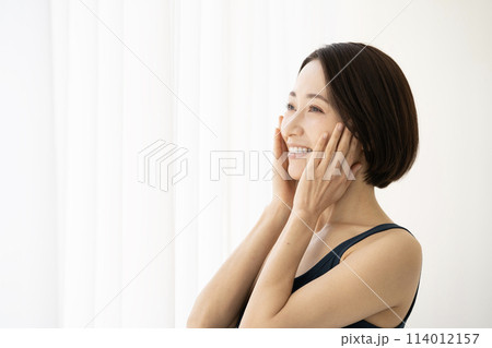 頬に手を添える女性の横顔 114012157