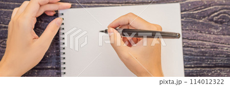 Women's hands in a wooden background holding a signboard, drawing block, paper, mockup BANNER, LONG FORMAT 114012322