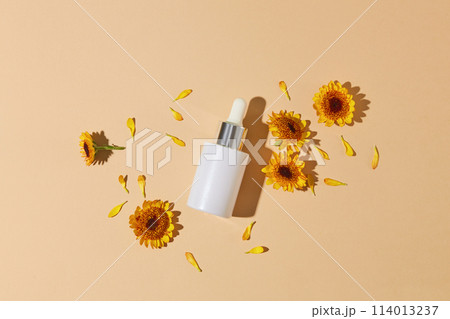 A glass bottle with dropper displayed with small petals and several Calendula flowers. Calendula flowers are commonly used for many other conditions A glass bottle with dropper displayed with small petals and several Calendula flowers. Calendula flowers are commonly used for many other conditions 114013237