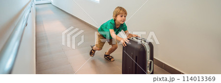 Funny little boy going on vacations trip with suitcase at airport, indoors BANNER, LONG FORMAT 114013369