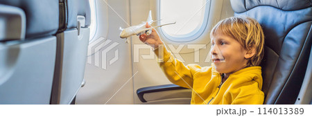 Little boy play with toy plane in the commercial jet airplane flying on vacation BANNER, LONG FORMAT Little boy play with toy plane in the commercial jet airplane flying on vacation BANNER, LONG FORMAT 114013389