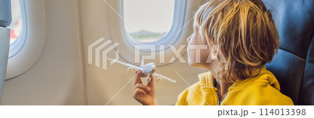 Little boy play with toy plane in the commercial jet airplane flying on vacation BANNER, LONG FORMAT Little boy play with toy plane in the commercial jet airplane flying on vacation BANNER, LONG FORMAT 114013398