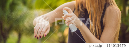 Woman spraying insect repellent on skin outdoor BANNER, LONG FORMAT 114013479