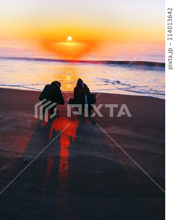 冬の北海道十勝川河口　朝焼けに染まる大津海岸にてジュエリーアイスを撮影する人 114013642