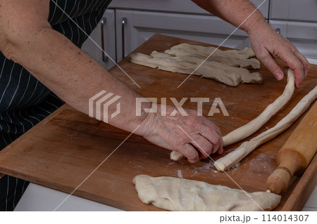 Woman kneading dough in kitchen.Women's hands knead the dough for dumplings 114014307