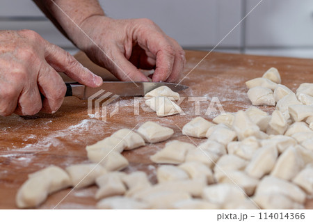 Woman kneading dough in kitchen.Women's hands knead the dough for dumplings 114014366